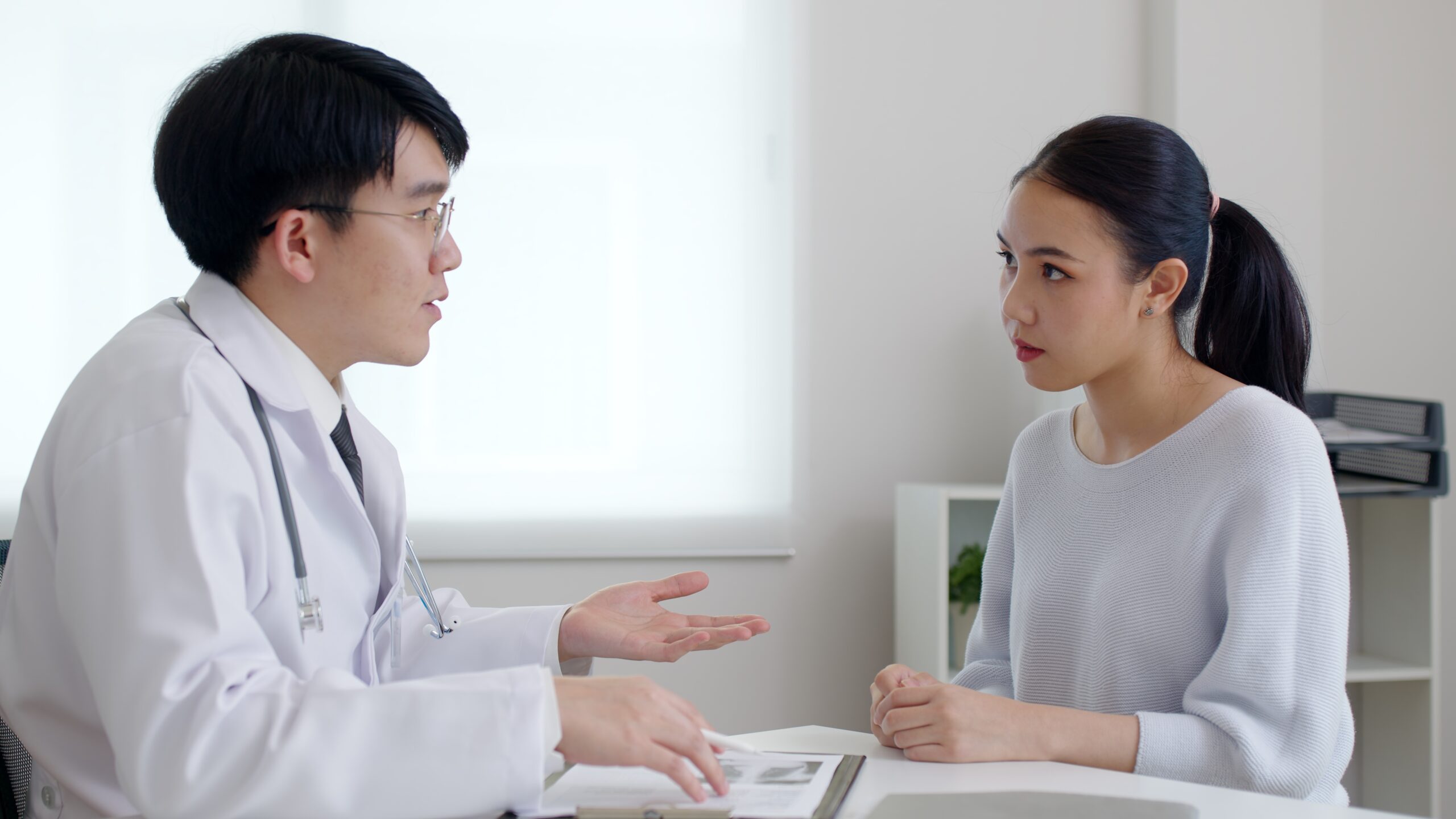 Plastic surgeon discussing procedure details with a patient during a consultation session.